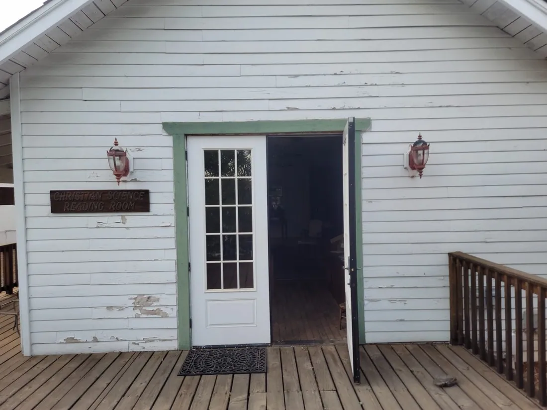 Wooden boardwalk and clapboard storefronts on a Gold Rush-era street.
